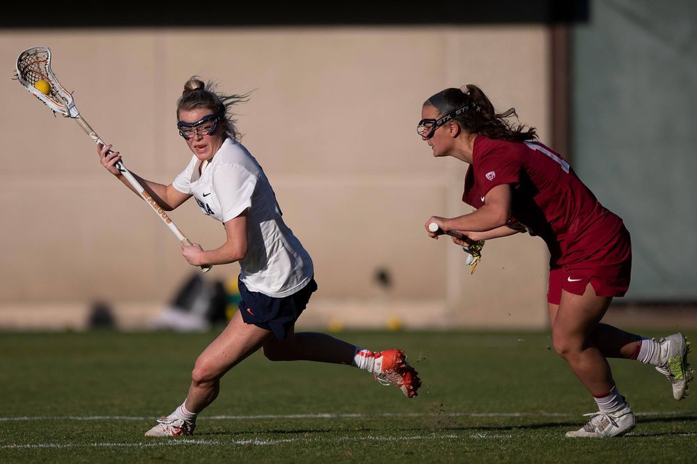 STANFORD, California - FEBRUARY 14:  Virginia Cavaliers midfield Courtlynne Caskin (25) is defended by Stanford Cardinal midfield Chelsea Trattner (16) during the second half at Cagan Stadium on February 14, 2020 in Stanford, California. The Virginia Cavaliers defeated the Stanford Cardinal 12-11. (Photo by Jason O. Watson)