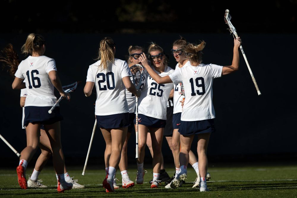 STANFORD, California - FEBRUARY 14:  Virginia Cavaliers midfield Courtlynne Caskin (25) is congratulated by teammates after scoring a goal against the Stanford Cardinal during the first half at Cagan Stadium on February 14, 2020 in Stanford, California. The Virginia Cavaliers defeated the Stanford Cardinal 12-11. (Photo by Jason O. Watson)